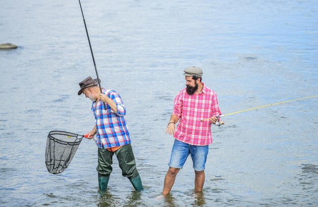 写真 男性の友情 父と息子の釣り 夏の週末 一緒に釣りをする 男性は水の中に立つ 釣りは魚以上のもの 釣り竿と網を持つ幸せな漁師 趣味とスポーツ活動