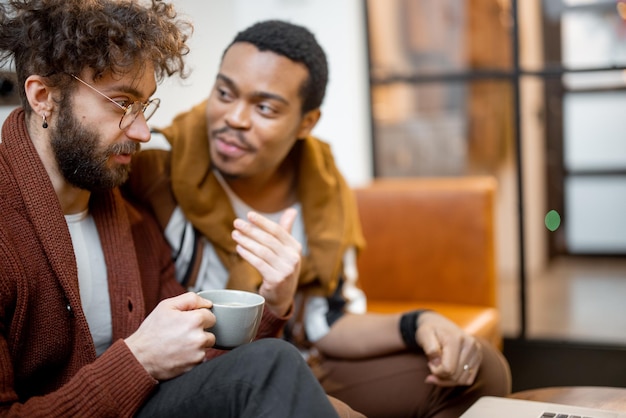 Male gay couple talking on a couch at home