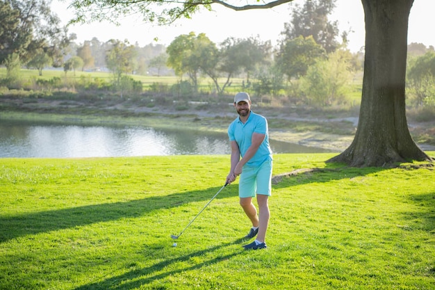 Male golf player on professional golf course golfer man with\
golf club taking a shot
