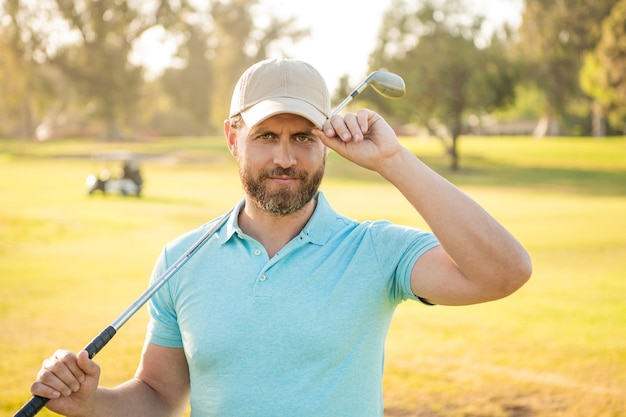 Male golf player on professional golf course. portrait of golfer in cap with golf club. people lifestyle. handsome man after game on green grass. summer activity. professional sport outdoor.