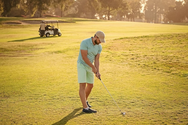 Male golf player on professional golf course portrait of golfer in cap with golf club