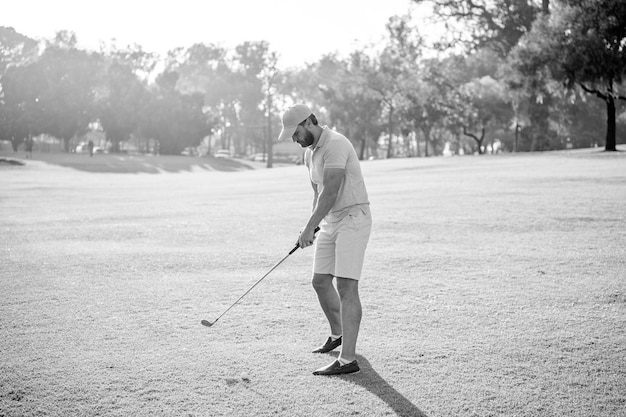 Male golf player on professional golf course portrait of golfer in cap with golf club