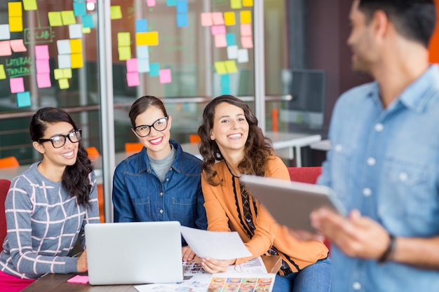 Male graphic designer interacting with his colleagues