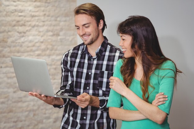 Male and graphic designers discussing over laptop