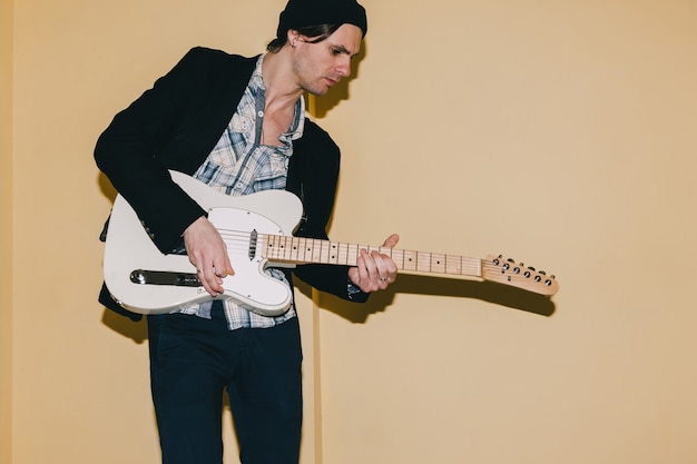 Male guitarist thoughtfully playing guitar