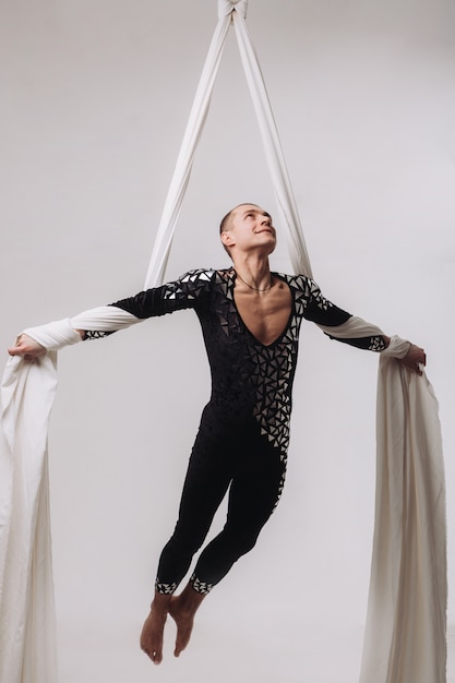 Male gymnast doing aerial silk acrobatics