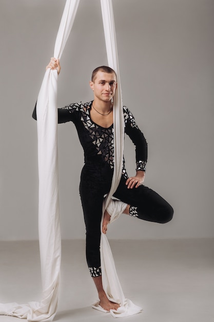 Male gymnast doing aerial silk acrobatics