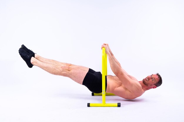 Male gymnast performing handstand on parallel bars studio shot