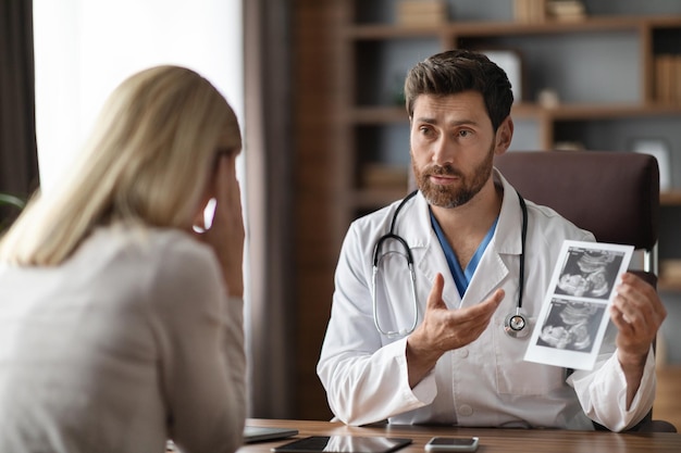 Premium Photo | Male gynecologist doctor consulting pregnant female ...