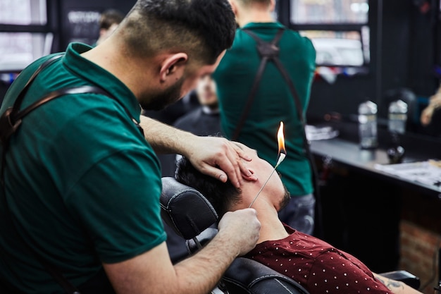 Male hairdresser cuts beard to man, barbershop, hairdresser