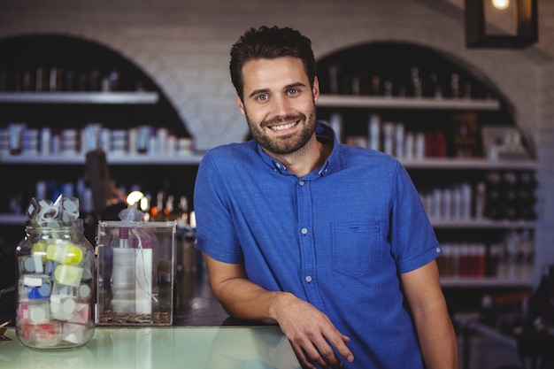 Male hairdresser leaning on table at a salon