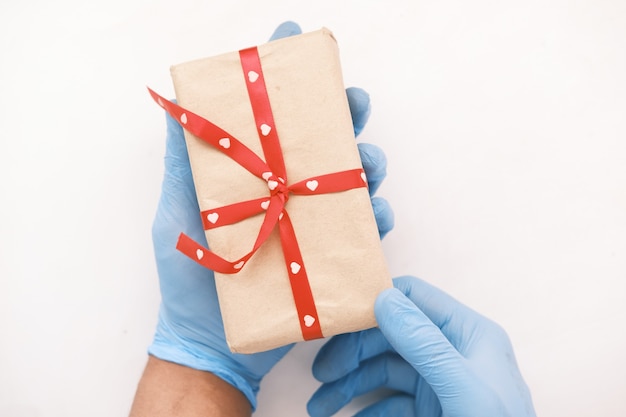 Male hand in a blue medical glove gives a gift