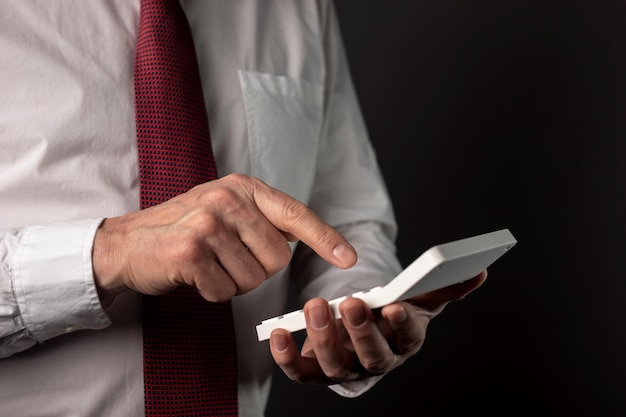 Male hand of businessman holding calculator