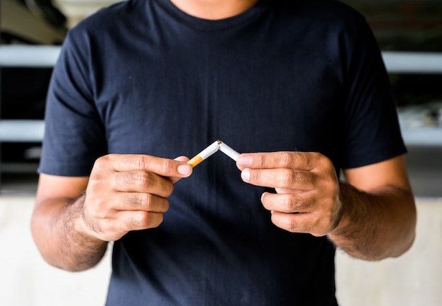 Male hand crushing cigarette.