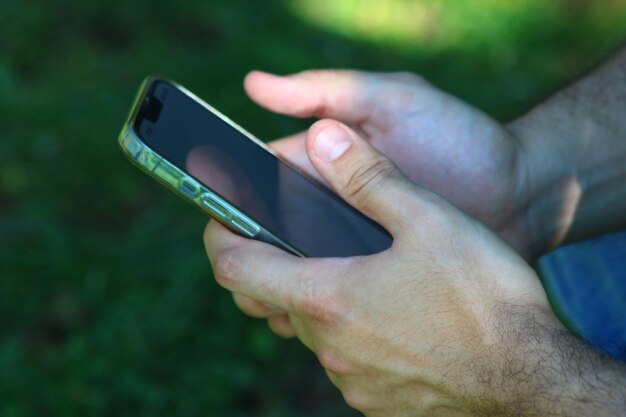 A male hand dealing with a smartphone