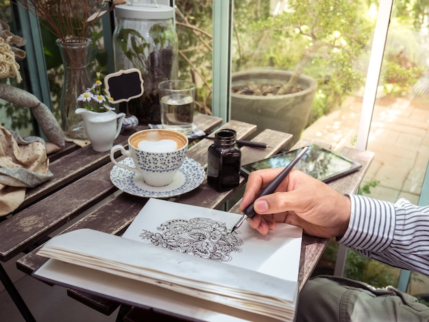 Linea arte di scarabocchio del disegno della mano maschio su carta con caffè e compressa