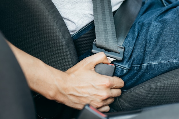 写真 車のシートベルトを締める男性の手