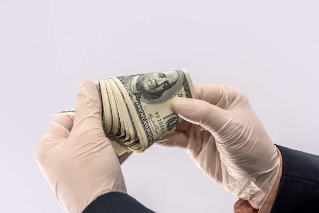 Male hand give dollar to pay in protective gloves  for safety isolated on white background. medical concept covid 19 coronavirus