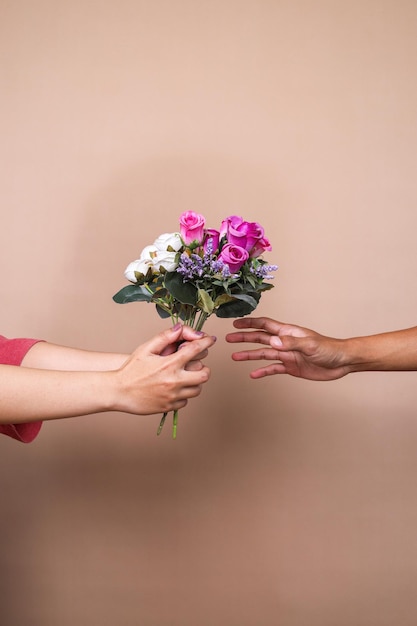 Foto la mano maschile che dà un bouquet di fiori e la mano femminile che lo prende