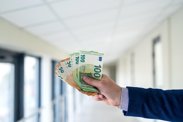 Male hand giving euro banknotes in office centr