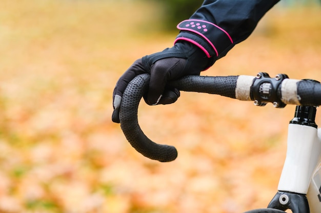 Foto mano maschile nel guanto al manubrio della bicicletta