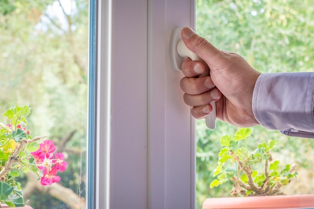 Male hand on the handle of a window