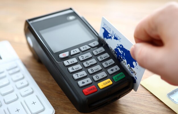Male hand hold credit card with pos terminal closeup