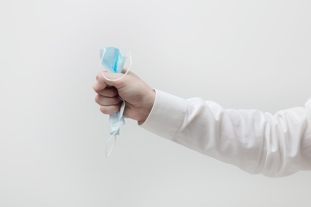 Male hand hold a lot of medical masks on the light background