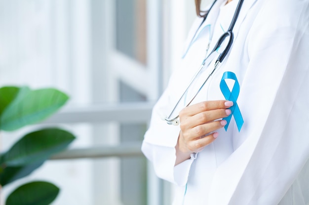 male hand holding blue prostate cancer awareness ribbon.