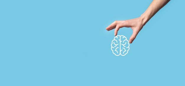파란색 배경에 뇌 아이콘을 들고 남자 손입니다. 인공 지능 기계 학습 비즈니스 인터넷 기술 개념.