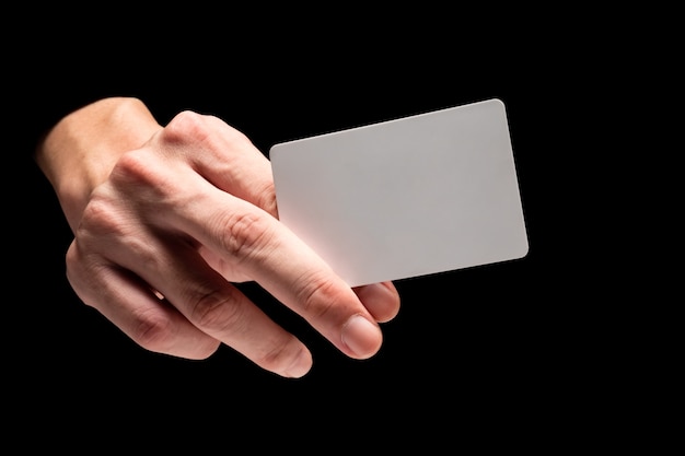 Male hand holding card on a black background