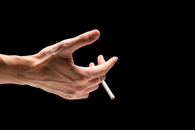 Photo male hand holding cigarette on a black background