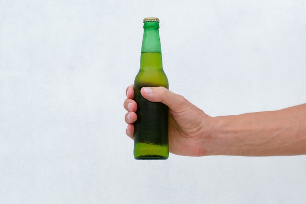 Male Hand Holding Cold Bottle of Beer. Lifestyle.
