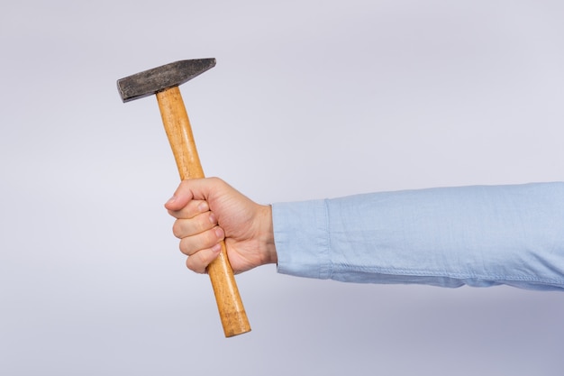 Photo male hand holding hammer on white.