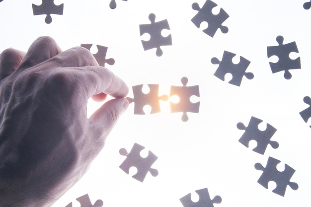 Photo male hand holding a jigsaw puzzle.