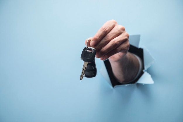 Photo male hand holding keys on blue scene
