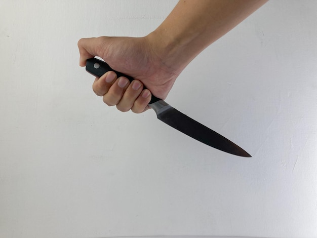 мужская рука, держащая кухонный нож, изолированная на белом фоне Концептуальная композиция опасной ситуации