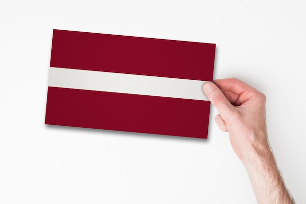 Male hand holding latvia flag