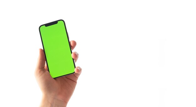 Male hand holding mobile phone with green display chroma key on white backgroundUsing electronic device smartphone online shopping working conceptCloseup shotCopyspacemockup