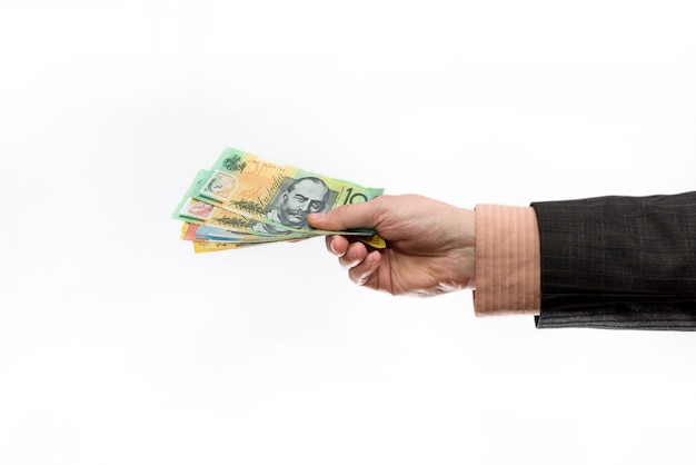 Photo male hand holding and offering australian dollar banknotes