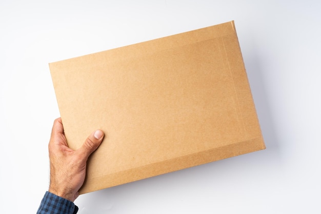 Male hand holding parcel post against white background