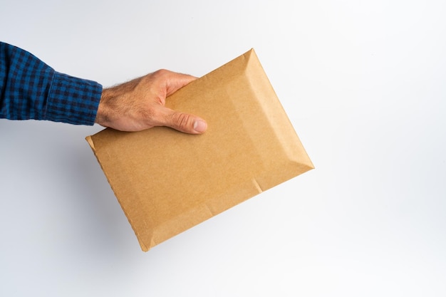 Male hand holding parcel post against white background