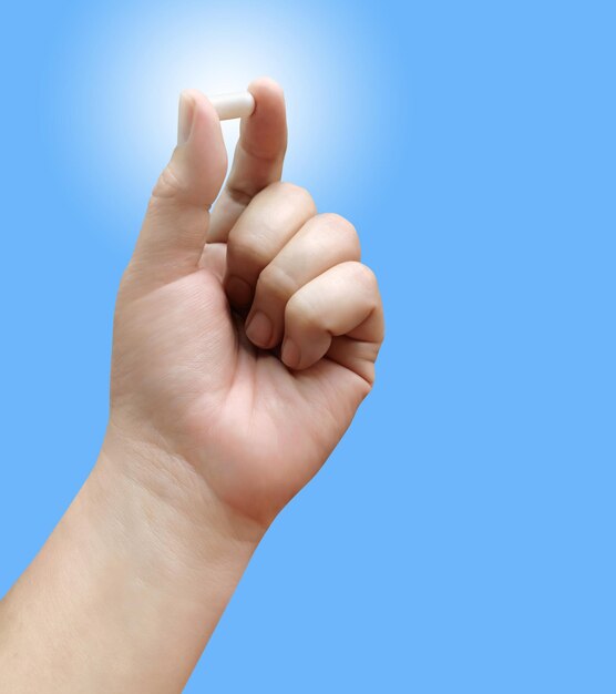 Male hand holding pills gesture lonely on a blue background