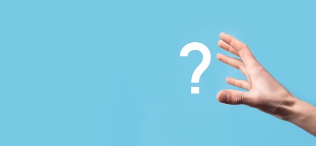 Male hand holding question mark icon on blue background.Banner with copy space. Place for text.