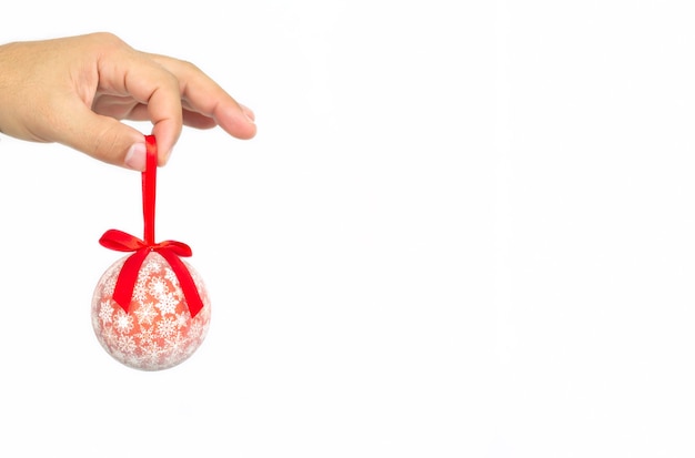 Male hand holding red christmas ball isolated on white background.