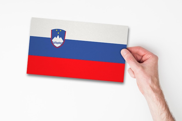 Foto mano maschile che tiene la bandiera della slovenia