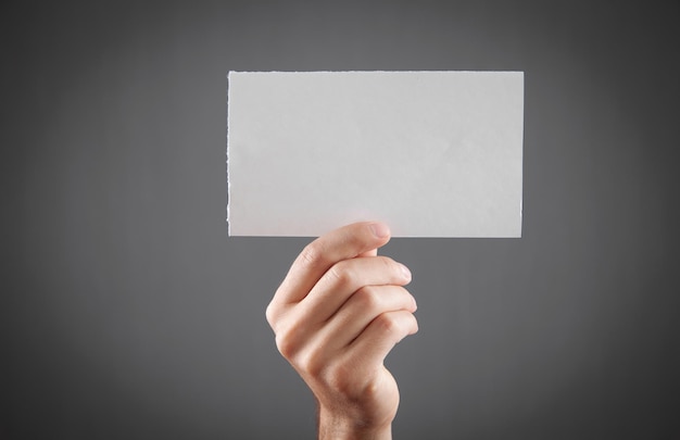 Male hand holding white blank paper