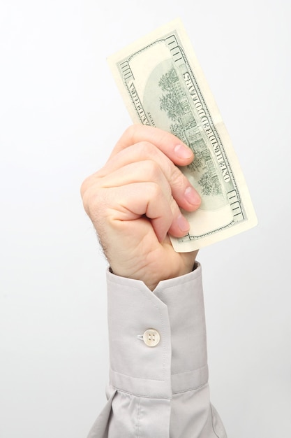 Male hand holds dollar banknotes on a white surface