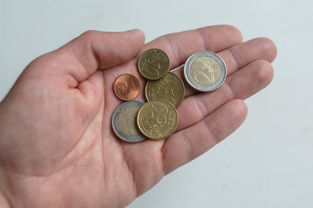 Male hand holds euro coins European currency with hand on a white background