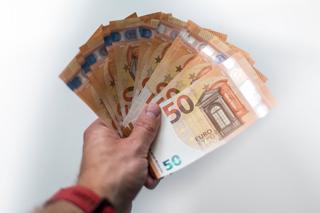 Male hand holds European money Euro on white background fifty euro currency banknotes